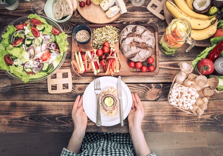 lunch at the table with different food, women's hands with a plate, the Concept of food and celebrationの写真素材