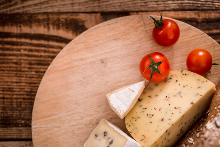 Cheese different slicing on a wooden plate close-up, food conceptの写真素材
