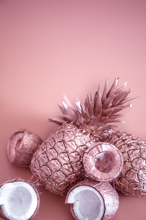 painted in gold fruit pineapple and coconut on a colored background, creative advertising design.Top viewの写真素材