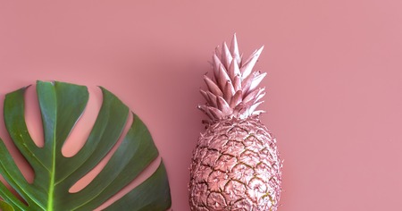 Fashionable color summer layout of fruits painted in gold color and tropical leaf, Pineapple on a colored background, creative advertising design.Top viewの写真素材