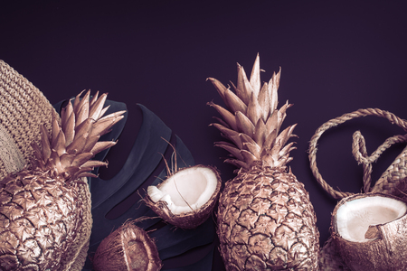 Summer tropical background with Golden pineapple and summer accessories on matte black background, creativity and style conceptの写真素材