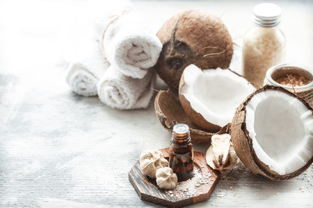 still life with coconut oil in a bottle and fresh coconut on a light background, spa therapy conceptの写真素材