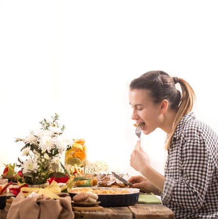 young woman eating at the festive Easter table , the concept of the celebrationの写真素材