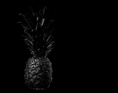 Black pineapple on black background Studio photo of delicious food, creative idea, place for textの写真素材