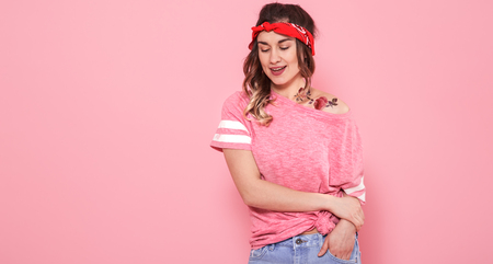 Horizontal portrait of hipster girl with tattoo, on pink background, lifestyle conceptの写真素材