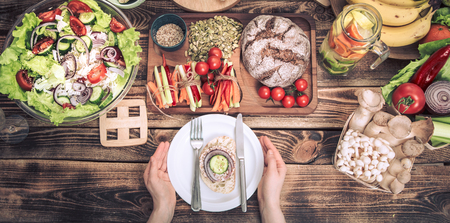 lunch at the table with different food, women's hands with a plate, the Concept of food and celebrationの写真素材