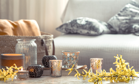 Still-life. Home cozy beautiful decor in the living room , a vase with spring flowers and candles on a wooden background , the concept of interior detailsの写真素材