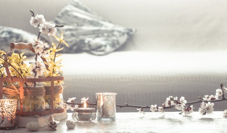 Still-life. Home cozy beautiful decor in the living room , a vase with spring flowers and candles on a wooden background , the concept of interior detailsの写真素材