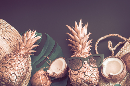 Summer tropical background with Golden pineapple and summer accessories with glasses, on a matte black background, the concept of creativity and styleの写真素材