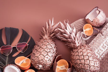 Summer tropical background with Golden pineapple and summer accessories with heart-shaped glasses, pastel background, creativity and style conceptの写真素材