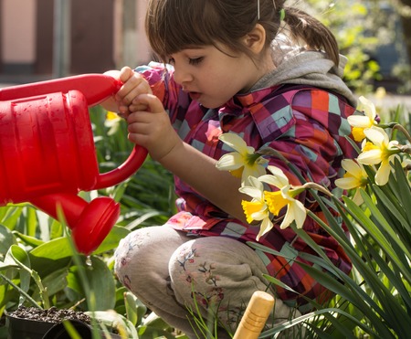Little girl planting flowers in the garden, Earth Day. Kid helping at the farm.の写真素材