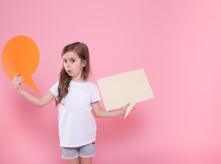 Cute little girl with speech icon on pink background .The concept of communication and communication . Studio shootingの写真素材