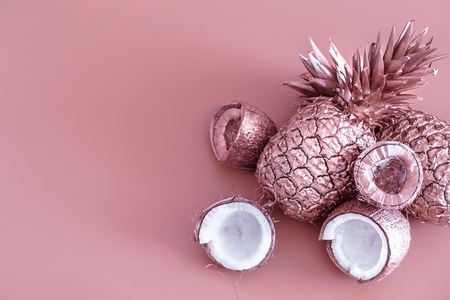 painted in gold fruit pineapple and coconut on a colored background, creative advertising design.Top viewの写真素材