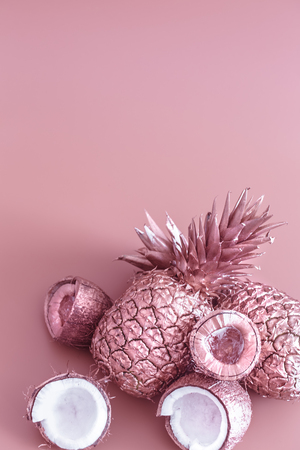 painted in gold fruit pineapple and coconut on a colored background, creative advertising design.Top viewの写真素材