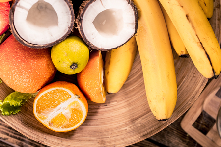 Fresh different organic fruits on wooden plate close up, healthy food conceptの写真素材