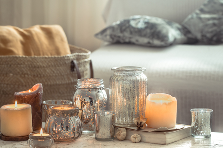 Still-life. Home cozy beautiful decor in the living room, vase and candles, on the background of a wooden table, interior details conceptの写真素材
