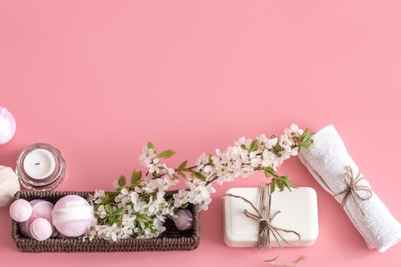 Spa still life on a pink background with spring flowers and organic body care products. The concept of Spa body careの写真素材