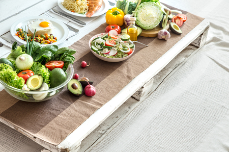 Organic healthy food at the light dining table in a homely atmosphere. The concept of healthy eating and home-cooked foodの写真素材