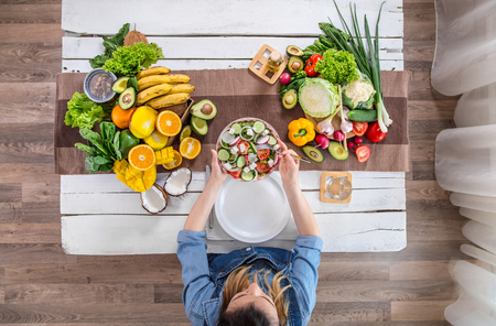Woman at the dining table with a variety of organic healthy food , top view. The concept of healthy eating and celebrationの写真素材