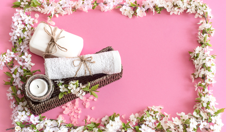Spa still life on an isolated pink background with spring flowers and organic body care productsの写真素材