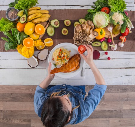 Woman at the dining table with a variety of organic healthy food , top view. The concept of healthy eating and celebrationの写真素材
