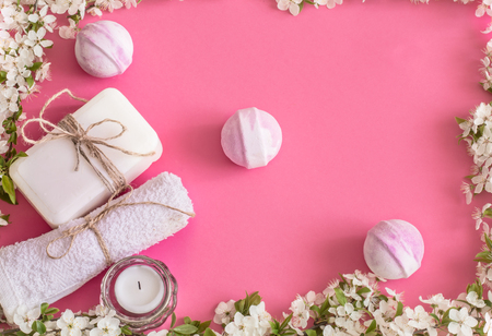 Spa still life on an isolated pink background with spring flowers and organic body care productsの写真素材