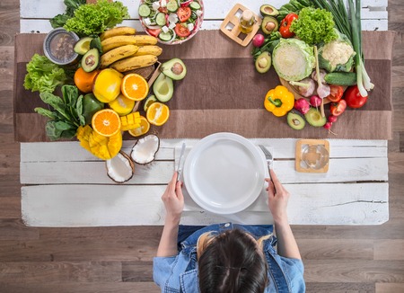 Woman at the dining table with a variety of organic healthy food , top view. The concept of healthy eating and celebrationの写真素材