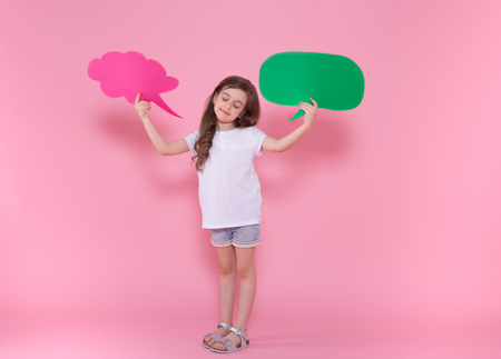 Cute little girl with speech icon on pink background .The concept of communication and communication . Studio shootingの写真素材