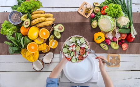 Woman at the dining table with a variety of organic healthy food , top view. The concept of healthy eating and celebrationの写真素材