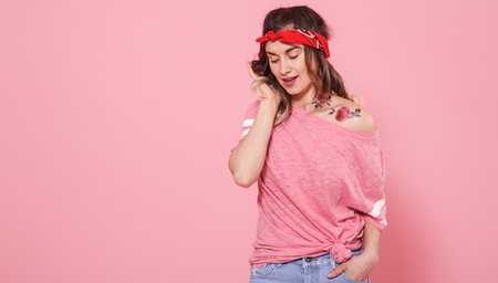 Horizontal portrait of hipster girl with tattoo, on pink background, lifestyle conceptの写真素材