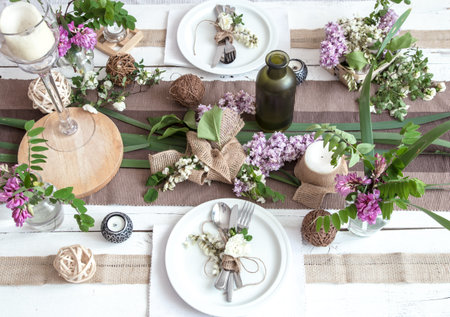 Beautifully elegant decorated table for holiday with spring flowers and greens - wedding or...