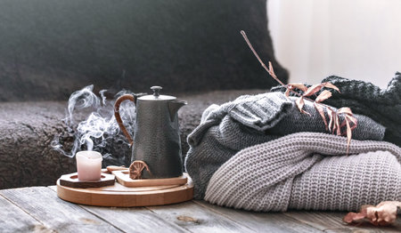 Cozy autumn morning breakfast in bed still life scene. Steaming cup of hot coffee, tea standing near...