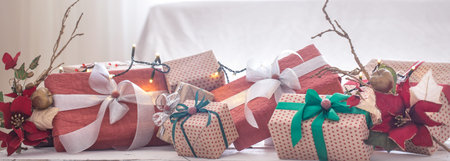 Christmas presents over Christmas lights and Christmas tree on light background. Colorful ribbons....