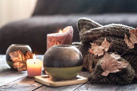 Cozy autumn morning breakfast in bed still life scene. Steaming cup of hot coffee, tea standing near window. Fall, Thanksgiving concept. White pumpkins, pine cones and oak leaves on wool plaid.の写真素材