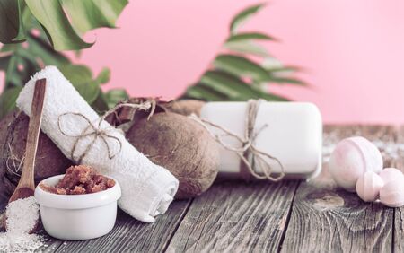 Spa and wellness setting with flowers and towels. Bright composition with tropical flowers on pink background. Dayspa nature products. Wooden spoonの写真素材