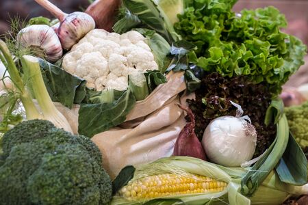 Display of fresh ripe organic broccoli, salad with greens and vegetables in cotton bag at the weekend farmer's market with blurred backgroundの写真素材