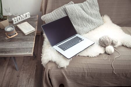 work at home with a computer on the couch .Home interior in a working atmosphere. Coziness and comfort.の写真素材