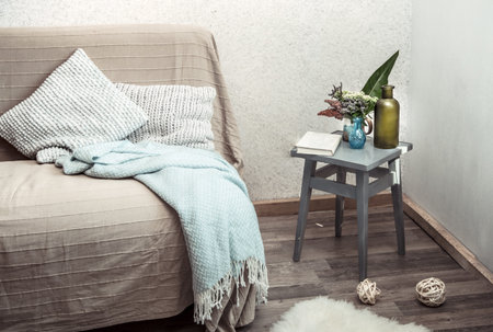 Home sofa with objects of cozy decor in the living room on a chair . The concept of decor and home...