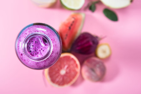 Glass bottles with natural detox drinks and a variety of fruits and vegetables on a colored background . Healthy food and drink concept. The view from the top.の写真素材