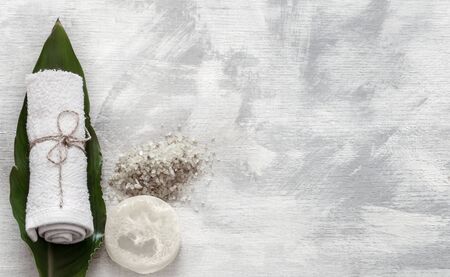Flat-lay natural cosmetics and accessories with tropical leaves to cleanse the skin. Basic hygiene and body care items on white background, copy space.の写真素材