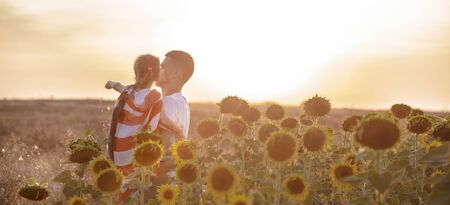 Happy family, dad and daughter holding the American flag at sunset. Dressed in white. The concept of family values and friendship . Patriotic feeling.の写真素材