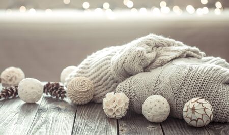 Cozy Christmas background on a wooden background with Christmas decorations and knitted sweater in a homely atmosphere.の写真素材