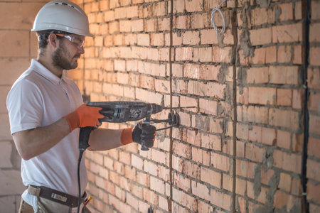 Handyman uses jackhammer, for installation, professional worker on the construction site. The...