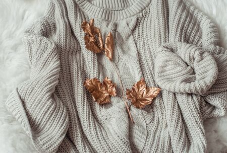 Hello Autumn flat lay background. Autumn background with cozy sweaters and gold leaves. Top view.の写真素材