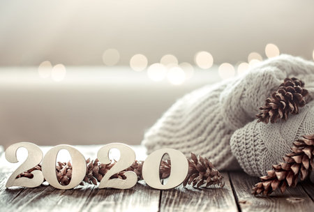 Cozy new year background new year 2020 on a wooden background with cones and knitted sweater in a...