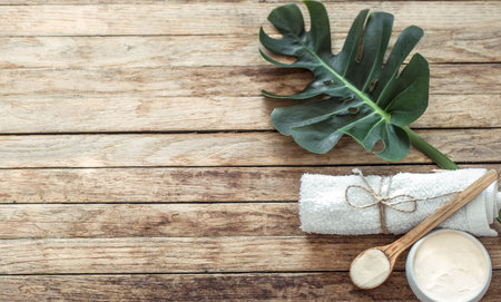 Spa composition with towels and tropical leaf on a wooden background. flat lay, copy space. The view from the top.の写真素材