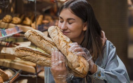 Only the best and fresh bakery. Young woman in supermarket with fresh bread . Health food. Healthy...