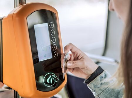 A young woman contactless pays for public transport. Payment by card, Bank transfer .の写真素材