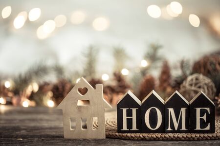 Festive background with lights and the inscription home on a wooden table. With festive decor items. The concept of Holiday and home comfort.の写真素材