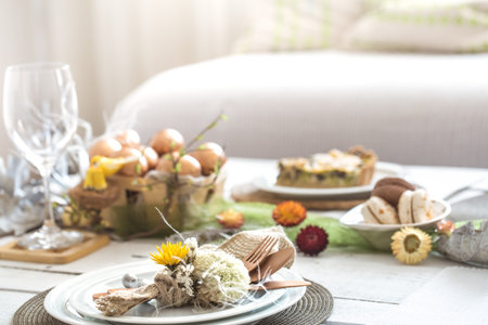 The interior of the room with a festive Easter table .A large white wooden table with a festive cake...